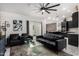 A modern living room features a black leather couch, armchairs, glass table, and a decorative ceiling fan at 102 S Honeysuckle Ln, Gilbert, AZ 85296