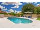 Inviting pool with tanning ledge, surrounded by lush landscaping, offers the perfect backyard oasis at 102 S Honeysuckle Ln, Gilbert, AZ 85296