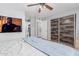 Comfortable bedroom featuring modern furnishings, a TV, and sliding closet doors at 10472 W Devonshire Ave, Phoenix, AZ 85037