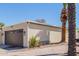 Detached two-car garage with decorative door and mature palm trees at 10472 W Devonshire Ave, Phoenix, AZ 85037