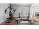 Home gym area with mirrored wall, weightlifting equipment, and rubber flooring at 10472 W Devonshire Ave, Phoenix, AZ 85037