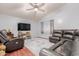Inviting living room with modern ceiling fan, plush leather seating and wood flooring at 10472 W Devonshire Ave, Phoenix, AZ 85037