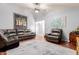 Inviting living room with modern ceiling fan, plush leather seating and wood flooring at 10472 W Devonshire Ave, Phoenix, AZ 85037