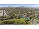 Scenic aerial view of a Primary-planned community with a lake, a golf course, and views of distant mountains at 1134 S 79Th Pl, Mesa, AZ 85208
