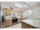 Well-lit kitchen with stainless steel appliances, light wood cabinets, and ample counter space at 1134 S 79Th Pl, Mesa, AZ 85208