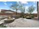 Backyard featuring a stone fire pit with built in bench seating and mature desert landscaping at 11623 W Marguerite Ave, Avondale, AZ 85323