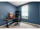 This bedroom offers gaming setup with blue walls, modern computer, and natural light from a window at 11623 W Marguerite Ave, Avondale, AZ 85323