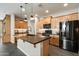 Modern kitchen featuring an island, black appliances, and wooden cabinets at 11623 W Marguerite Ave, Avondale, AZ 85323