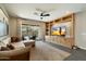 Comfortable living room featuring built-in shelving, a ceiling fan, and sliding door to the patio at 11623 W Marguerite Ave, Avondale, AZ 85323