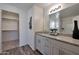 Bathroom featuring vanity with granite countertops, a decorative mirror, and walk-in closet space at 1179 N 13Th St, Coolidge, AZ 85128