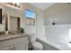 This bathroom boasts a modern vanity with granite countertop, bathtub with white subway tile, and a window for natural light at 1179 N 13Th St, Coolidge, AZ 85128