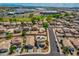 Aerial view showcasing neighborhood homes, street, desert trees, and distant industrial buildings at 13171 W Redfield Rd, Surprise, AZ 85379