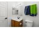 Neutral half bathroom with wooden vanity and toilet and blue and yellow towels hanging at 13171 W Redfield Rd, Surprise, AZ 85379