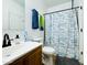 Bright bathroom featuring a classic sink, toilet, and shower with a modern patterned curtain at 13171 W Redfield Rd, Surprise, AZ 85379