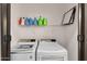 Bright laundry room features modern washer and dryer, wire shelving, and fresh air filter at 13171 W Redfield Rd, Surprise, AZ 85379