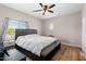 Main bedroom features a gray bed frame, white bedding, ceiling fan, and outside view at 13171 W Redfield Rd, Surprise, AZ 85379