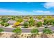 An elevated view shows a well-planned community with mature trees, single-Gathering homes, and scenic desert surroundings at 15216 W Westview Dr, Goodyear, AZ 85395