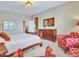 Bright bedroom features a wooden bed frame, dresser, and cozy red floral patterned armchairs at 15216 W Westview Dr, Goodyear, AZ 85395