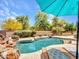 Private backyard with a rock waterfall pool, lush landscaping, and a lounge deck at 15216 W Westview Dr, Goodyear, AZ 85395