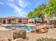 Private backyard with a rock waterfall pool, lounge deck, and green landscaping at 15216 W Westview Dr, Goodyear, AZ 85395