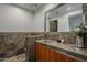 A contemporary bathroom vanity with a granite countertop, wood cabinets, a large mirror, and stylish fixtures at 15217 N 15Th Dr, Phoenix, AZ 85023
