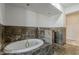 A luxurious bathroom with a large soaking tub, granite tile, and recessed lighting at 15217 N 15Th Dr, Phoenix, AZ 85023