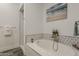 Bright bathroom featuring a soaking tub with marble surround and stylish tile accents at 15217 N 15Th Dr, Phoenix, AZ 85023