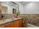Bathroom features a unique stone tile backsplash, modern vanity, and stainless steel faucet at 15217 N 15Th Dr, Phoenix, AZ 85023