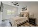 Cozy bedroom features a tufted headboard, ceiling fan, and window with views at 15217 N 15Th Dr, Phoenix, AZ 85023