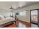The main bedroom features hardwood floors, a ceiling fan, large windows with a view, and access to a patio at 15217 N 15Th Dr, Phoenix, AZ 85023