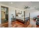 A spacious main bedroom with four-poster bed, wood floors, and an attached bathroom and walk-in closet at 15217 N 15Th Dr, Phoenix, AZ 85023