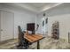 Office featuring a wooden desk, modern chair, and doorway view to the home's stairway at 15217 N 15Th Dr, Phoenix, AZ 85023