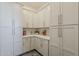 Pantry room with bright gray painted cabinets, stone countertops and grey floors at 15217 N 15Th Dr, Phoenix, AZ 85023
