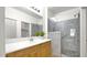 Bright bathroom featuring a glass-enclosed shower and a wooden vanity with sleek countertop at 17132 W Tara Ln, Surprise, AZ 85388