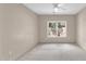 Bright, neutral bedroom with a ceiling fan and window overlooking a verdant yard at 17132 W Tara Ln, Surprise, AZ 85388