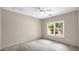 Bright bedroom featuring a ceiling fan and a window overlooking trees at 17132 W Tara Ln, Surprise, AZ 85388