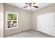Neutral bedroom with a ceiling fan, carpeted floor, and window overlooking trees at 17132 W Tara Ln, Surprise, AZ 85388
