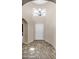 Bright foyer with decorative light fixture, neutral walls and tiled floors at 17132 W Tara Ln, Surprise, AZ 85388