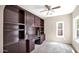 Office area with custom built-in shelving and a built in desk, filled with natural light at 17132 W Tara Ln, Surprise, AZ 85388