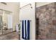 Bathroom featuring a tiled shower, dark tile flooring, and a large vanity mirror at 19029 N 36Th St, Phoenix, AZ 85050