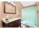Updated bathroom features a modern vanity with marble countertop and framed mirror, complemented by a shower with a light blue curtain at 19029 N 36Th St, Phoenix, AZ 85050