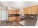 Well-maintained kitchen features wooden cabinets, dark countertops, and tile floors at 19029 N 36Th St, Phoenix, AZ 85050