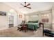 Spacious main bedroom with a ceiling fan, carpet, and an attached bathroom with white cabinetry at 19029 N 36Th St, Phoenix, AZ 85050