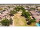 An aerial view showcases a lush green community park with a basketball court, playgrounds, and mature trees at 1932 S Arroyo Ln, Gilbert, AZ 85295