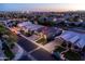 Dusk aerial view of home in a quiet neighborhood with street lighting and well-kept lawns at 1932 S Arroyo Ln, Gilbert, AZ 85295