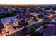 Sunset aerial view of home showcasing professional landscaping, 3 car garage, and welcoming neighborhood at 1932 S Arroyo Ln, Gilbert, AZ 85295