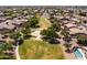 An aerial view showcases a lush green community park with mature trees, a basketball court, and walking paths at 1932 S Arroyo Ln, Gilbert, AZ 85295