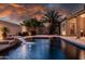 Captivating backyard showcasing a luxurious pool with water feature, complemented by palm trees and inviting patio space at 1932 S Arroyo Ln, Gilbert, AZ 85295