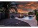 Stunning view of the sparkling pool, enhanced by tropical palm trees and lush landscaping at 1932 S Arroyo Ln, Gilbert, AZ 85295