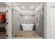 Bathroom boasts an open shower, free-standing tub, mosaic tile accents, and access to a walk-in closet at 1932 S Arroyo Ln, Gilbert, AZ 85295